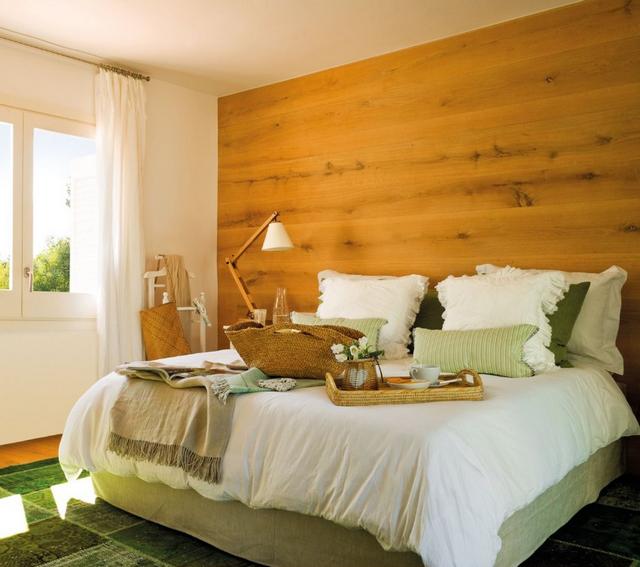 Hálószoba fa falburkolattal zöld tónusú lakástextil